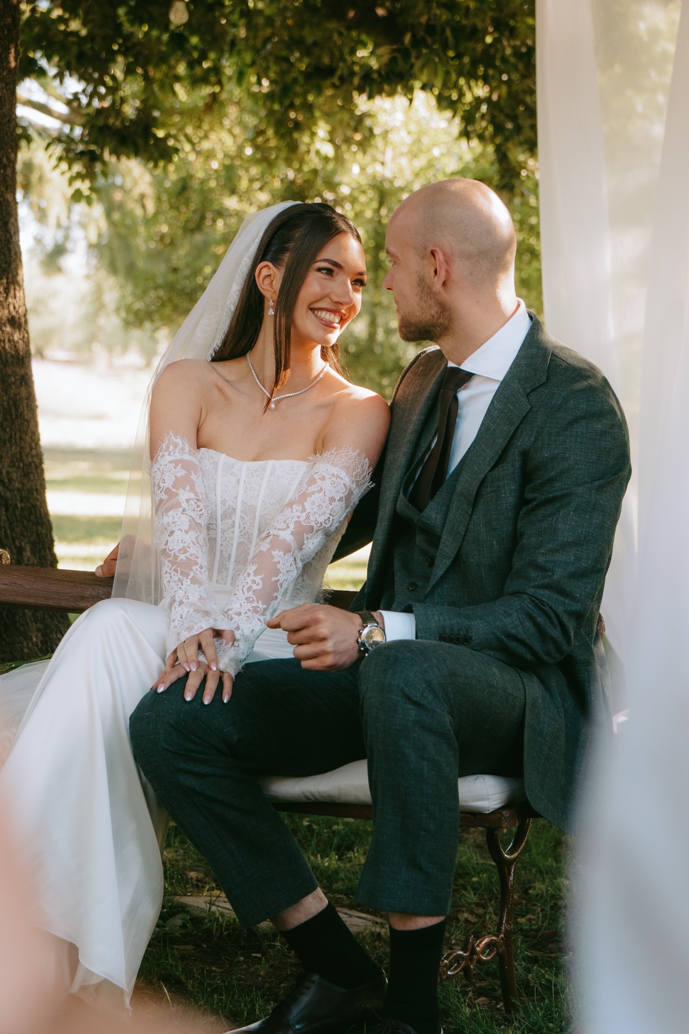 The couple seated together in dappled garden light.