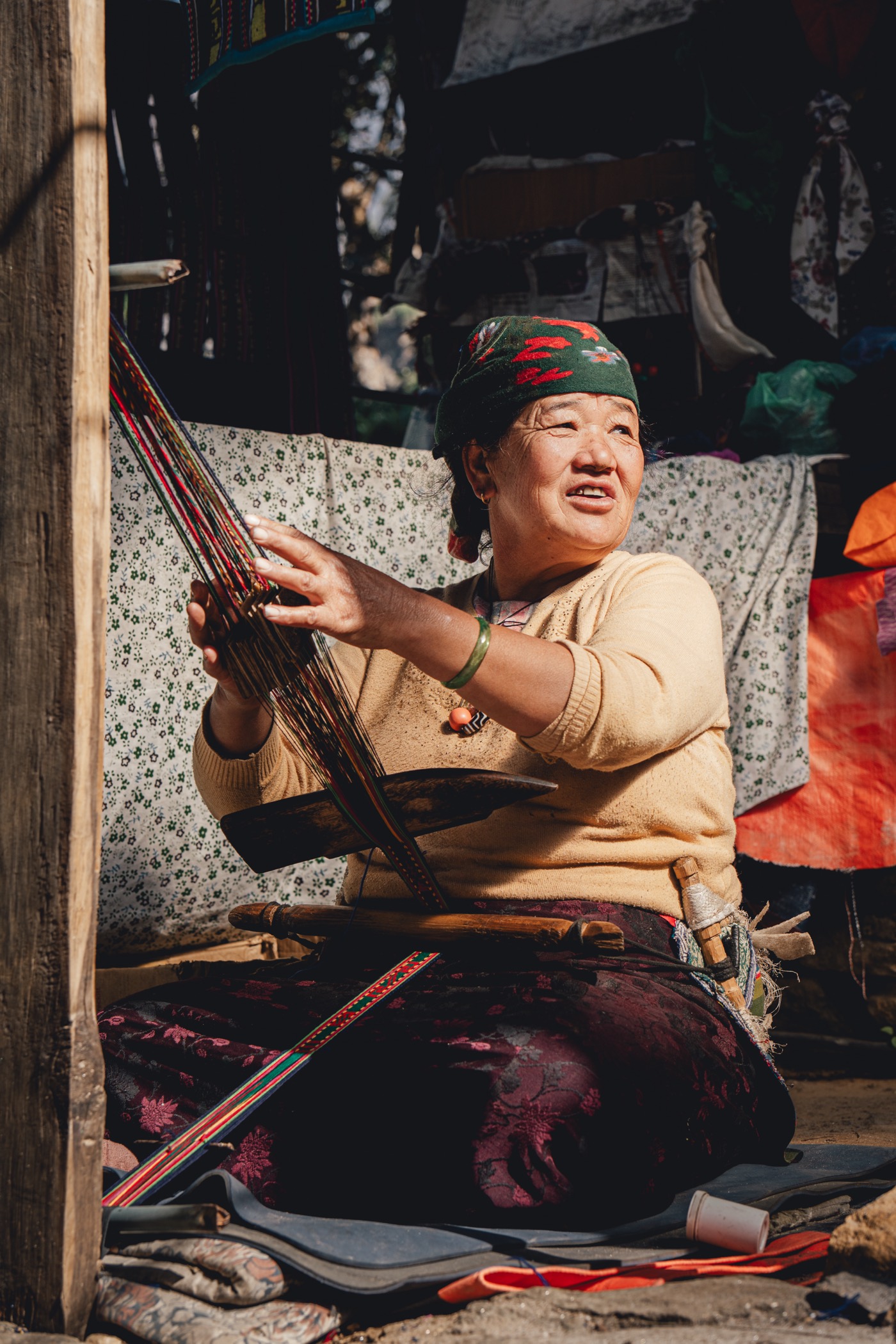 A woman seated at her work, playing a stringed instrument.